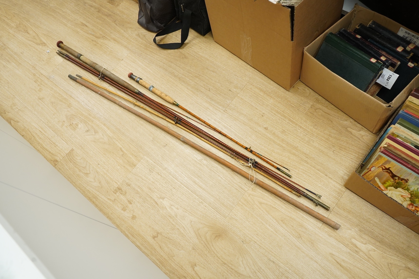 A collection of split cane fishing rods, reels, landing net etc contained in a large wooden box